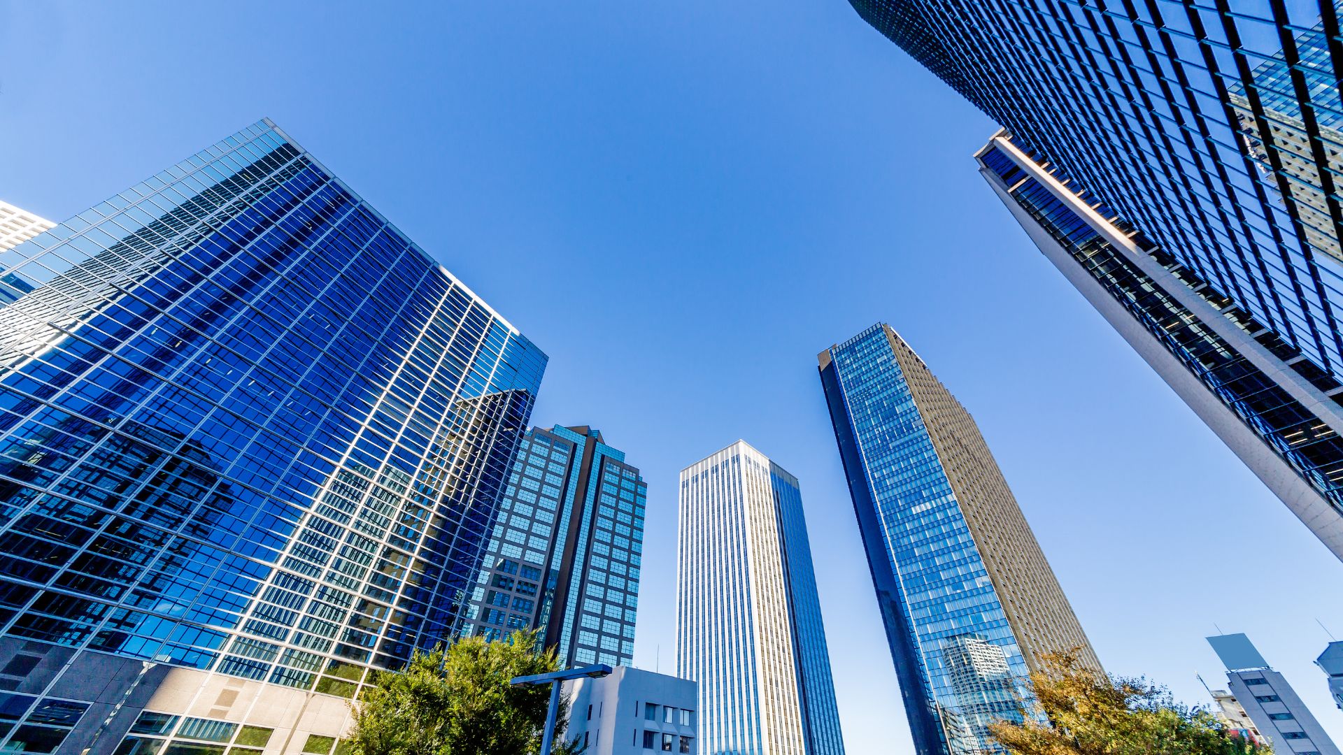 Modern glass skyscrapers against bright blue sky in urban business district