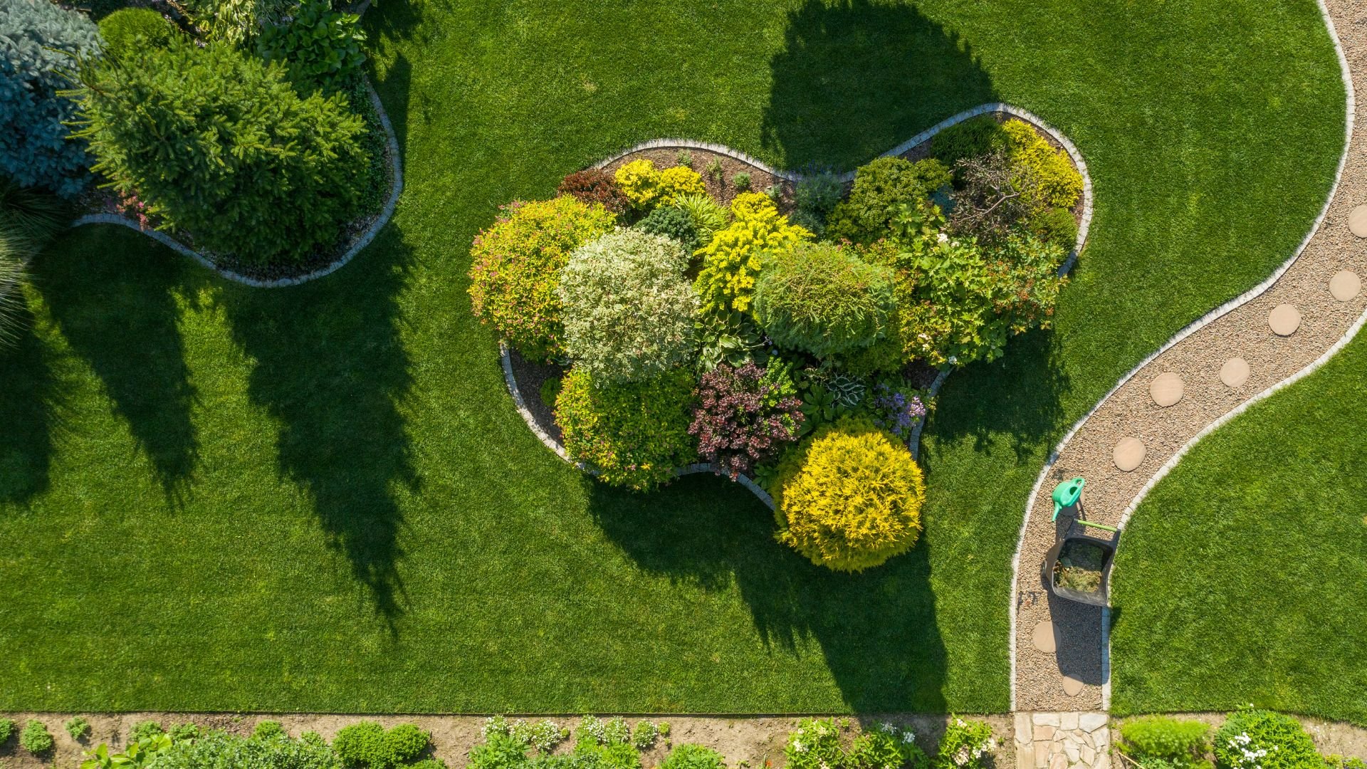 Aerial view of landscaped garden with colorful plants and curved stone path